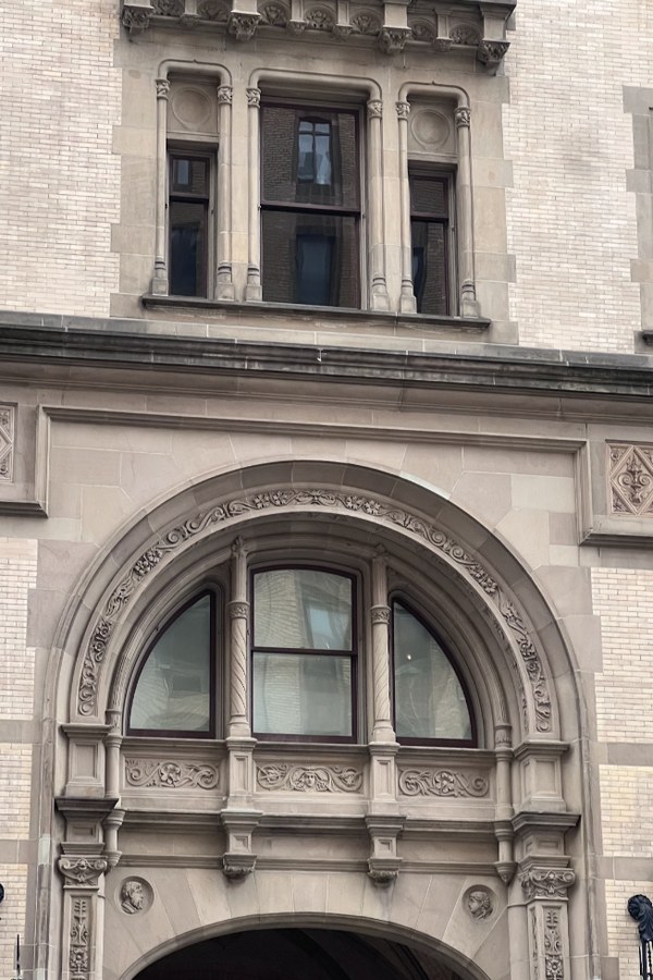 Limestone entrance arch with a half-round window and carved detail